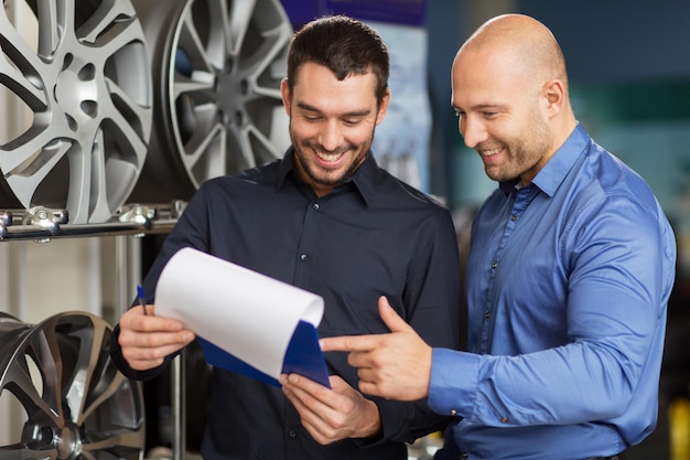 business maintenance people concept male customer choosing alloy wheel rims salesman with clipboard car repair service auto store 380164 188488